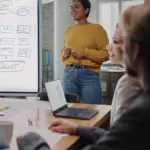 AdobeStock_415116776 woman presenting in a meeting